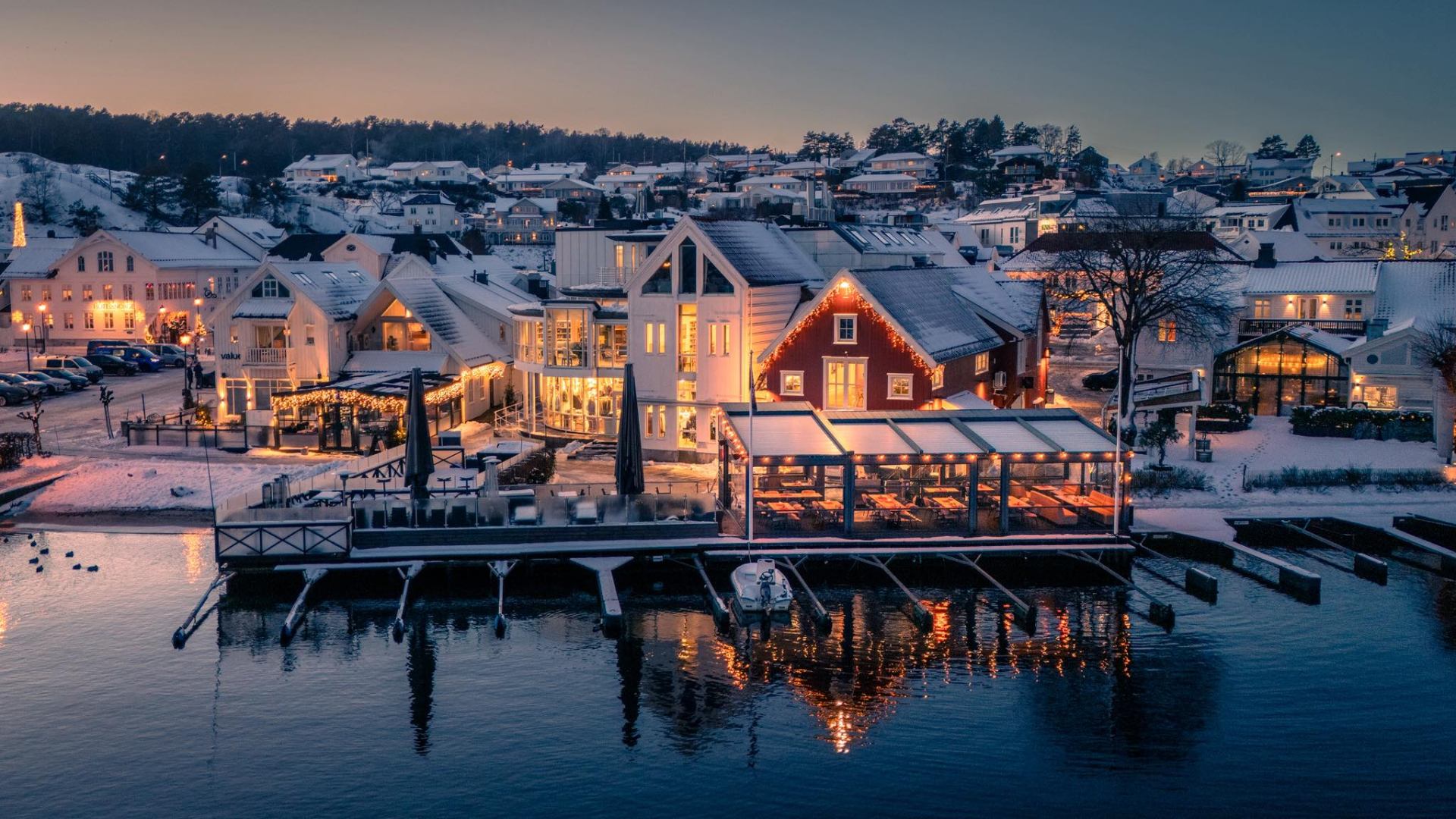 Sjøbua opplyst en vinterkveld ved havna i Lillesand